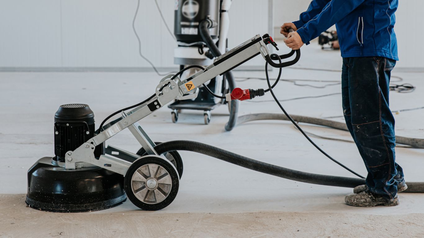 Worker using a floor polishing machine for epoxy polishing.